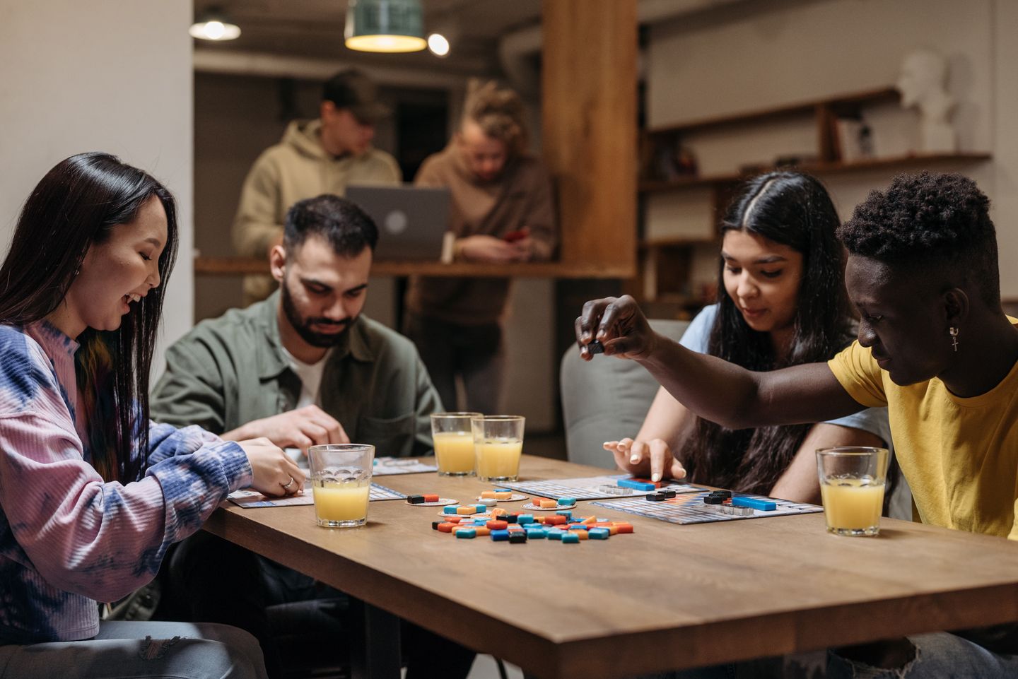 Friends enjoying a board game and colorful drinks around a table