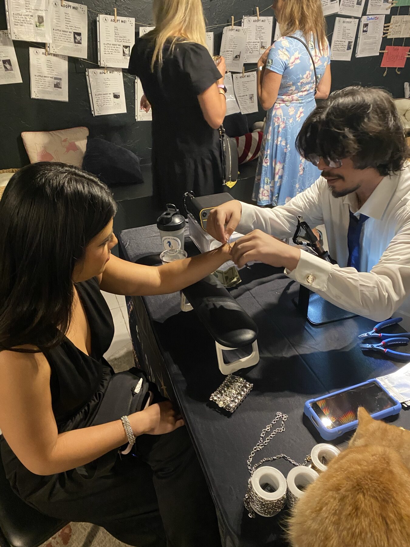 Chris fitting permanent jewelry for a customer at a Starmarked event